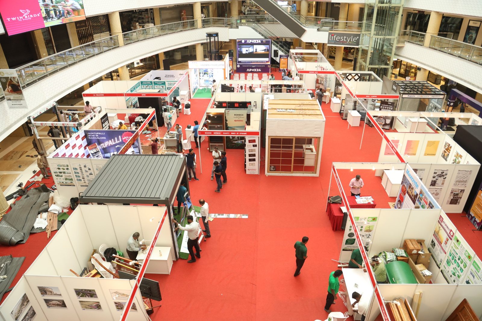 Large exhibition floor with branded stalls and red carpet